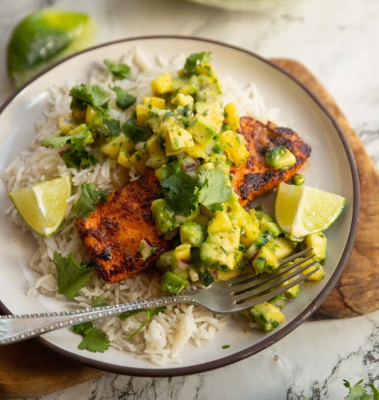 chipotle salmon served with mango salsa chipotle salmon served with mango salsa on small white plate with rice