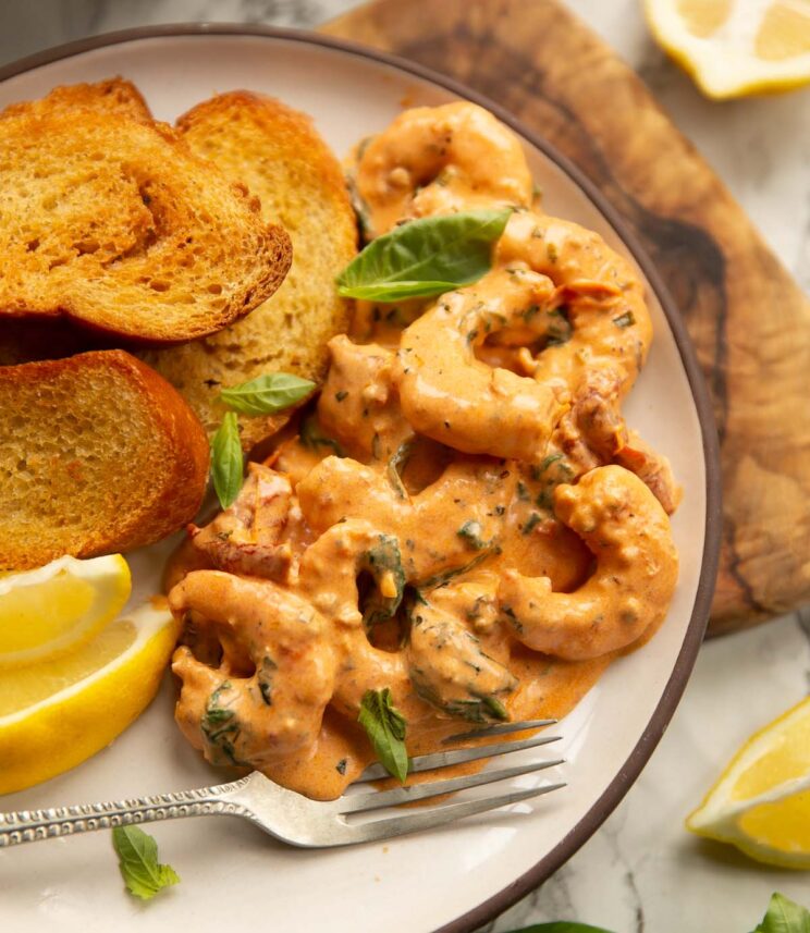 creamy tuscan style prawns creamy tuscan style prawns served on small white plate with toasted bread and lemon wedges