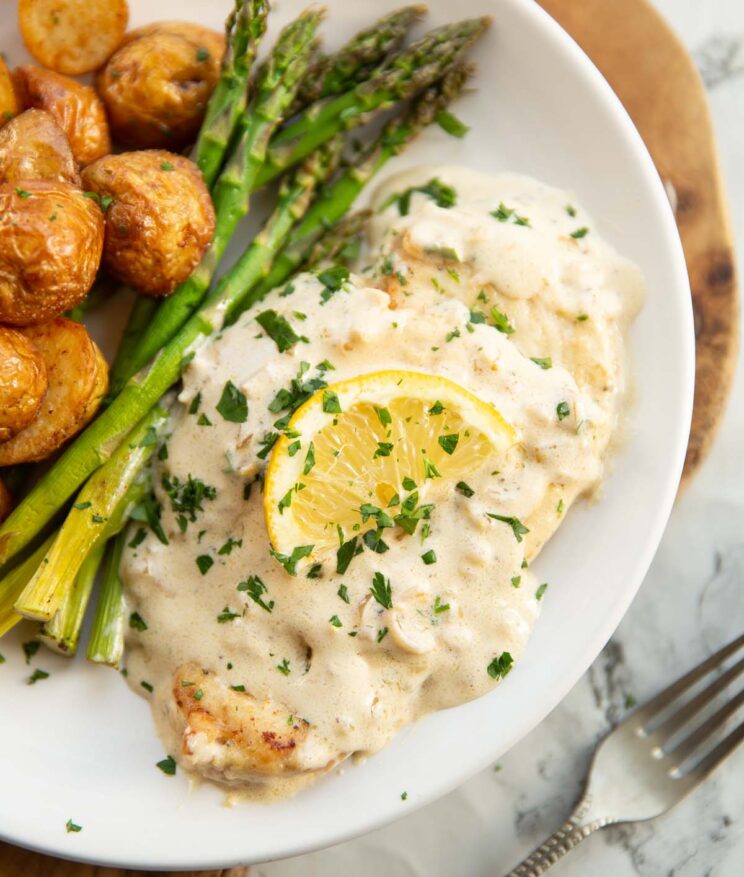 creamy lemon chicken creamy lemon chicken served on small white plate with asparagus and baby potatoes
