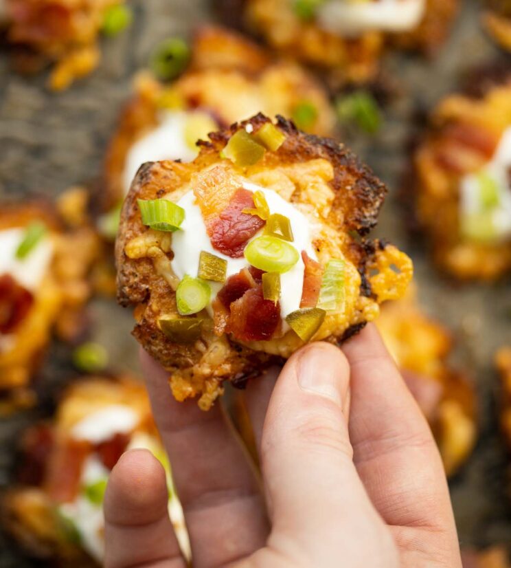 loaded smashed potato close up overhead shot of hand holding loaded smashed potato