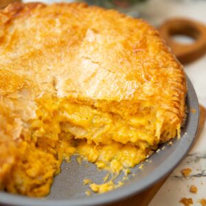 close up shot of cheese potato onion pie in dish with slice taken out