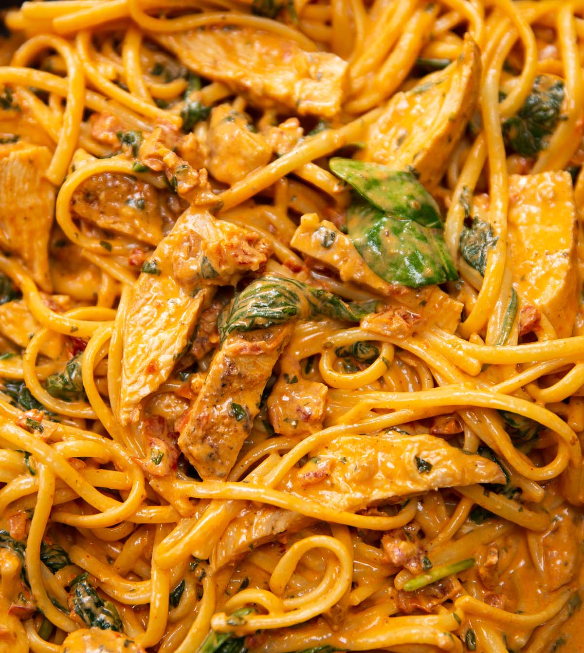 close up shot of tuscan chicken pasta in pan