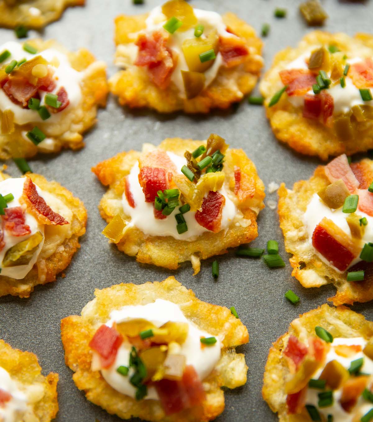close up shot of smashed tater tots on large grey tray